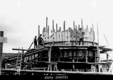 Bauarbeiter auf dem Gerüst der aufkommenden Kläranlage Ochsenfurt. [Automatisierte Übersetzung] Stockfoto