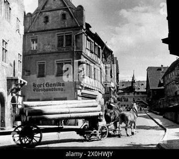 Ein Pferdewagen mit Baumstämmen in der Hauptstraße von Ochsenfurt. [Automatisierte Übersetzung] Stockfoto