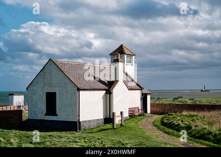 Seaton Sluice Watch House Museum , Wachturm und St Mary's Leuchtturm in der Ferne an der Northumberland Küste. Stockfoto