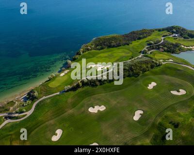 Blick aus der Vogelperspektive auf den Golfplatz neben dem Meer Stockfoto