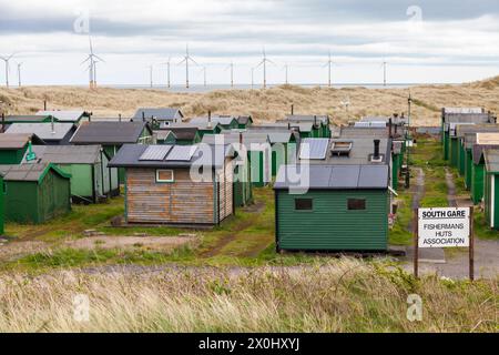 Die fishermens Hütten am South Gare, Redcar, England, Großbritannien mit Offshore- Windenergieanlagen im Hintergrund Stockfoto