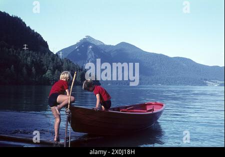 Kinder, die mit einem Ruderboot am Ufer spielen [automatisierte Übersetzung] Stockfoto