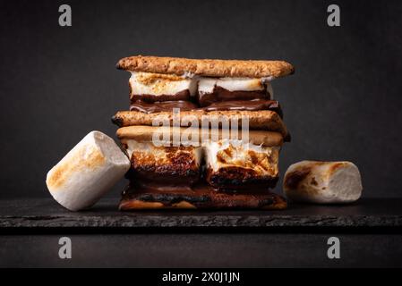 Frisch geröstete Smores. Köstliches Marshmallow-Sandwich mit Cracker und Schokolade auf dunklem Hintergrund. Stockfoto