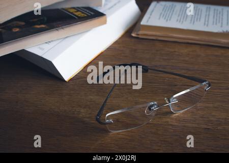 Klassische Gläser und Bücherstapel auf dem Tisch. Literaturkonzept. Brillen neben alten Büchern. Bildung und Wissen. Forschungskonzept. Club buchen Stockfoto