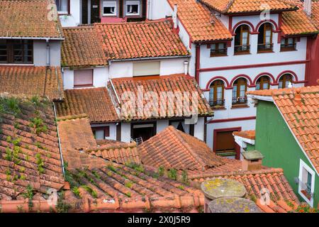 Eine Gruppe von Gebäuden mit roten und weißen Dächern gruppiert sich in der malerischen Küstenstadt Cudillero, Asturien, Spanien. Die einzigartige Architektur Stockfoto