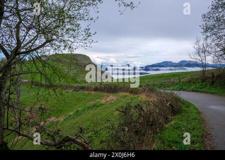 Kurvenreiche Straße durch die nebelbedeckten Asturien-Berge in Spanien. Die Straße verbiegt und biegt sich entlang des rauen Geländes und bietet eine Herausforderung Stockfoto