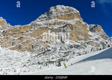 Skifahrer auf der Abfahrt von Col Pradat vor dem schneebedeckten Gipfel Sassongher, Wintersportort Colfosco, Kolfosco, Skigebiet Alta Badia, Dolomiten, Südtirol, Italien Stockfoto