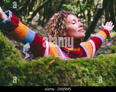 Profil einer entspannten Frau, die in einem grünen Wald frische Luft atmet. Umwelt und gesunder Lebensstil weibliche Menschen in Outdoor-Freizeitaktivitäten öffnen Arme und umarmen die Natur mit Liebe. Waldreisen Stockfoto