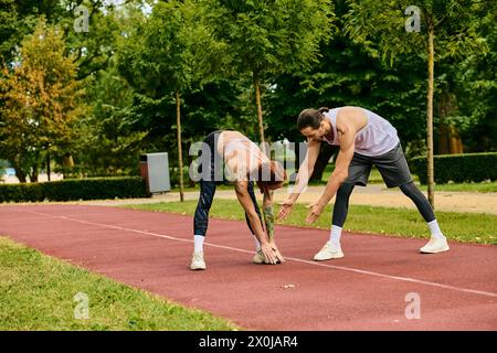 Eine entschlossene Frau in Sportbekleidung, geführt von einem Personal Trainer, trainiert gemeinsam auf einer Strecke. Stockfoto