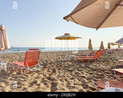 Leere Liegestühle am frühen Morgen am Strand von Gouves auf der Urlaubsinsel Kreta Stockfoto