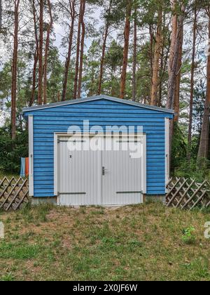 Blick vom öffentlichen Weg zu einer blauen Holzgarage im nordischen Stil im Wald des Ostseebades Prerow, Fischland Darss, Mecklenburg-Vorpommern, Deutschland Stockfoto