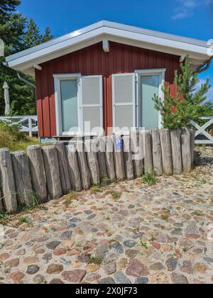 Deutschland, Mecklenburg-Vorpommern, Halbinsel Fischland-Darß-Zingst, Blick über Kopfsteinpflaster im Vordergrund zu einem kleinen schönen Ferienhaus an der Ostseeküste im Ferienort Prerow Stockfoto