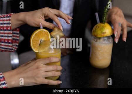 Die Hände von Mutter und ihrer lateinamerikanischen Tochter teilen sich einen Obstdrink. Nicht erkennbar. Muttertag und gesunde Lebenskonzepte Stockfoto