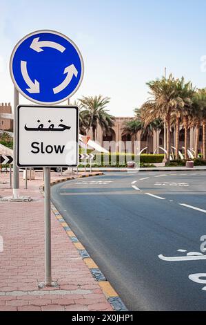 Ein Straßenschild zwingt Sie, in Gegenwart eines Kreisverkehrs langsam zu fahren Stockfoto