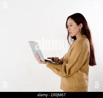 Rothaarige Geschäftsfrau arbeitet mit ihrem Laptop isoliert in weißem Hintergrund Stockfoto