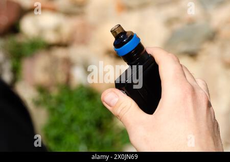 Die Hand eines Mannes hält eine elektronische Zigarette. Neue Technologien und Schadstoffe Stockfoto