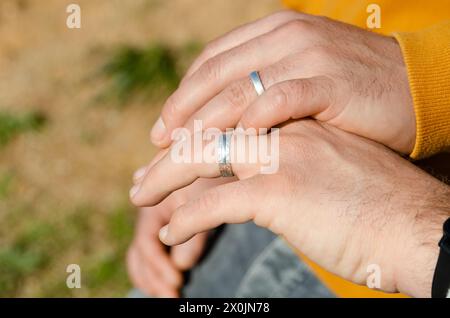 Zwei homosexuelle Männer, die mit Verlobungsringen die Hand schütteln. Homosexualitätsbegriff, Homosexualehen und LGBTI-Konzept Stockfoto
