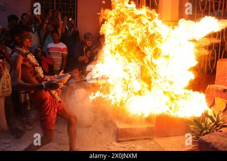 Kalkutta, Indien. April 2024. 12. April, Kalkutta, Indien: Ein hinduistischer Anhänger wirft Feuer auf das Tor eines Shiva-Tempels während eines Ritual of Shiva Gajan Hindu Festivals in Kalkutta, Indien, am Freitag. Treue Hindugläubige bieten jedes Jahr verschiedene Rituale an, in der Hoffnung, die Gunst des hinduistischen Gottes Shiva zu gewinnen. Quelle: Eyepix Group/Alamy Live News Stockfoto