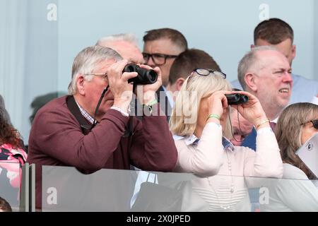 12. April 2024; Aintree Racecourse, Aintree, Merseyside, England: 2024 Grand National Festival Day 2; Zuschauer verfolgen die Rennen mit einem Fernglas Stockfoto