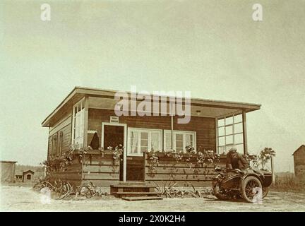 Zuhause GER, 20240101, Aufnahme ca. 1930, Mann mit seinem Motorrad vor seinem haus *** zu Hause GER, 20240101, Foto ca. 1930, Mann mit seinem Motorrad vor seinem Haus Stockfoto