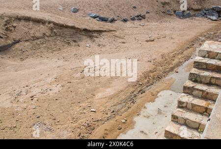 Sand, Steine und Leiter auf dem Gebäude oder in der Grube in Spanien. Natur Textur und Körnung im Sommer Sonnentag. Stockfoto