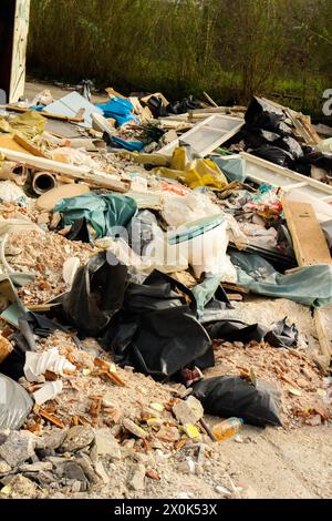 Tauchen Sie ein in die eindringliche Landschaft des urbanen Verfalls und der Umweltzerstörung mit diesem beeindruckenden Bild eines Müllbergs in einer verlassenen Fabrik Stockfoto