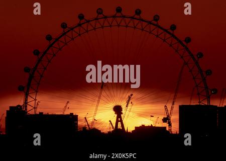 London, Großbritannien. April 2024. Wetter in Großbritannien: Dramatischer Sonnenuntergang hinter dem Riesenrad London Eye endet am Freitag mit überdurchschnittlich hohen Temperaturen in der Stadt. Guy Corbishley/Alamy Live News Stockfoto