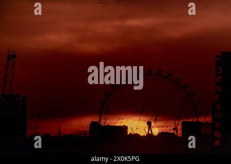 London, Großbritannien. April 2024. Wetter in Großbritannien: Dramatischer Sonnenuntergang hinter dem Riesenrad London Eye endet am Freitag mit überdurchschnittlich hohen Temperaturen in der Stadt. Guy Corbishley/Alamy Live News Stockfoto