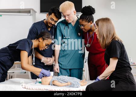 Eine Gruppe von Ärzten in professioneller Kleidung, die aufmerksam um ein Baby herum stehen, wahrscheinlich eine medizinische Untersuchung durchführen oder Behandlungsoptionen besprechen. Stockfoto