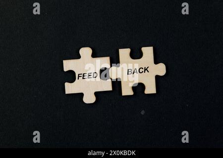 Nahaufnahme von verstreuten Puzzleteilen, die sich zu dem Wort „FEEDBACK“ in weißen Buchstaben zusammenfügen. Stockfoto