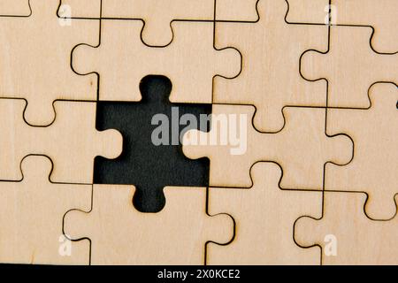 Zusammengesetzte Puzzleteile auf einem Holzbrett symbolisieren die Zusammenarbeit und strategische Planung Stockfoto