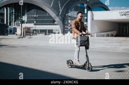 Geschäftsmann mit Elektromobil, der in der Stadt mit urbaner Architektur pendelt Stockfoto