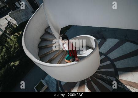 Selbstbewusste Geschäftsfrau, die bei Tageslicht die Treppe im Freien hinabsteigt Stockfoto