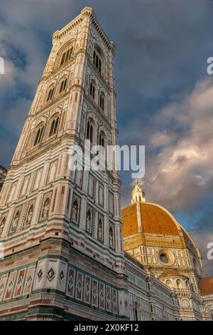 Florenz, Italien - 4. April 2024: Giotto Campanile mit der Kuppel der Kathedrale Santa Maria del Fiore auf der Piazza del Duomo mit warmem Sonnenuntergang Stockfoto