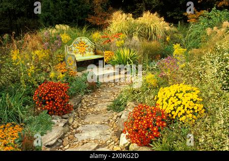 Handgemalte, fröhliche mexikanische handgefertigte Bank im Sonnengarten im Mittleren Westen der USA Stockfoto