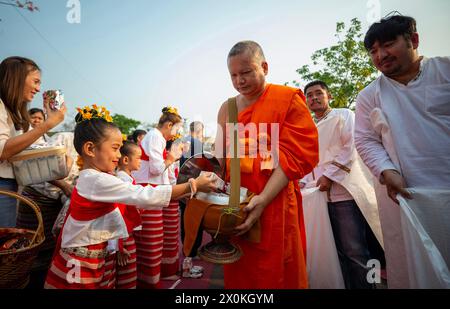 Chiang Mai, Thailand. April 2024. Ein Kind in traditionellen Kostümen bietet den buddhistischen Mönchen während der Feierlichkeiten zum 728. Jahrestag der Stadt Chiang Mai Essen. Die Stadt Chiang Mai wurde am 12. April 1296 von den drei Königen König Mangrai, König Ngam Mueang und König RAM Khamhaeng gegründet. (Foto: Pongmanat Tasiri/SOPA Images/SIPA USA) Credit: SIPA USA/Alamy Live News Stockfoto