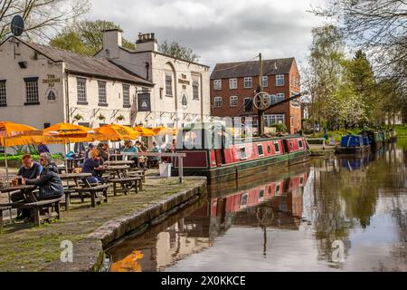 Schmalboote auf dem Shropshire union Kanal vor dem Shroppie fly Pub im Dorf Cheshire Audlem, wo Menschen essen und trinken Stockfoto