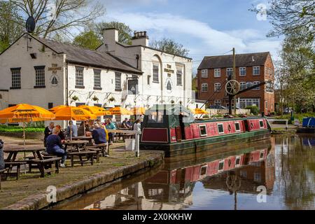 Schmalboote auf dem Shropshire union Kanal vor dem Shroppie fly Pub im Dorf Cheshire Audlem, wo Menschen essen und trinken Stockfoto