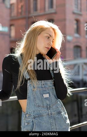 Junge Frau am Telefon in Hamburgs Speicherstadt. Stockfoto