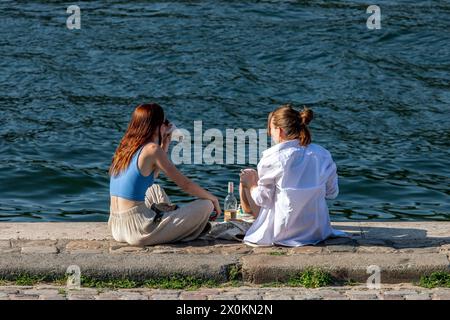 Junge Leute, die an den Ufern der seine sitzen, Paris, Frankreich Stockfoto