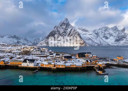 Aus der Vogelperspektive auf den Berg Olstinden und die Insel Sakrisoya in reiner Bay im Winter, Lofoten Islands, Norwegen. Stockfoto