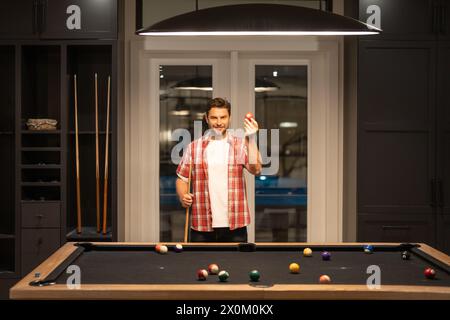 Billard. Ein Kerl spielt Billard. Der Mann hat im Billardzimmer einen Ball im Billard-Zimmer geschlagen. Russische Billard-Billard. Snooker-Player. Junger Profi-Mann spielt Stockfoto