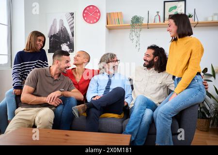 Fröhliche kaukasische, vielfältige Familie zusammen auf Sofa im Wohnzimmer und sich gegenseitig anschauen. Stockfoto