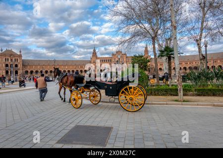 Sevilla, Spanien - 3. März 2024: Pferdekutschen, die Touristen über die Plaza de España in Sevilla transportieren Stockfoto