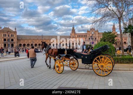 Sevilla, Spanien - 3. März 2024: Pferdekutschen, die Touristen über die Plaza de España in Sevilla transportieren Stockfoto