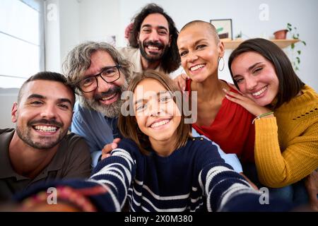 Fröhliche kaukasische Familie lächelt sich umarmt und macht ein Selfie-Foto drinnen. Glückliche Menschen im häuslichen Leben. Stockfoto