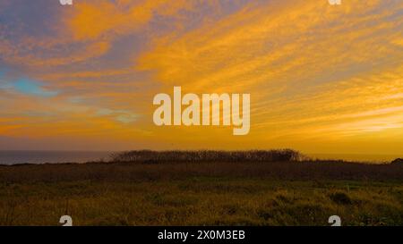 Rote Sonnenuntergangswolken über Four Mile Beach, Kalifornien. Stockfoto