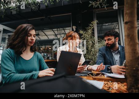 Das Startup-Team führt eine dynamische Diskussion in einer städtischen Kaffeebar Stockfoto