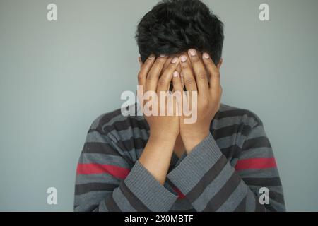 Nahaufnahme eines traurigen Mannes, der das Gesicht mit der Hand bedeckt. Stockfoto