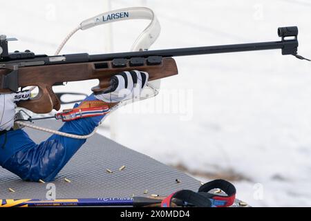 Sportlerbiathletin-Gewehrschießen in Bauchlage. Selektiver Fokus, extreme Nahaufnahme. Biathlet im Schießstand offener Jugendbiathlonwettbewerb Stockfoto
